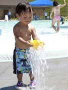 Toddler playing with water at a splash pool