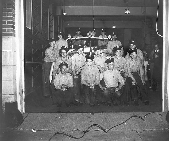 Historic photo of Ames Firefighters posing in front of a small fire vehicle. 