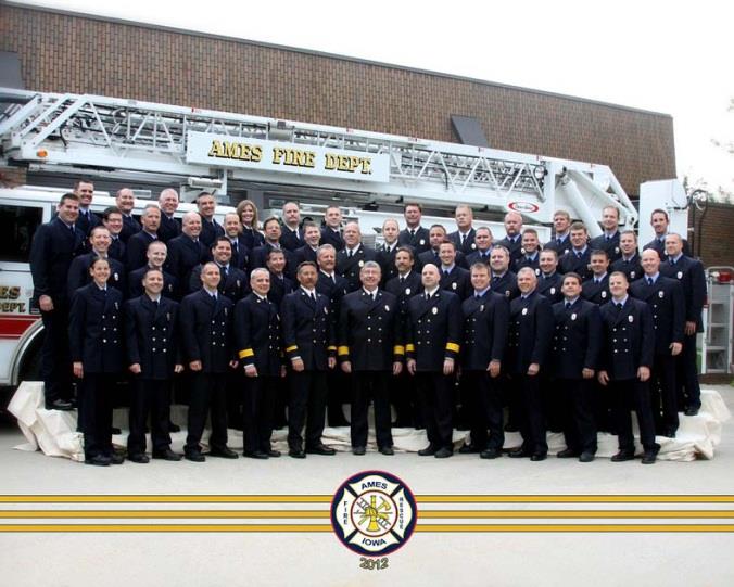 43 members of the Ames Fire Department posed in front of a Fire truck.